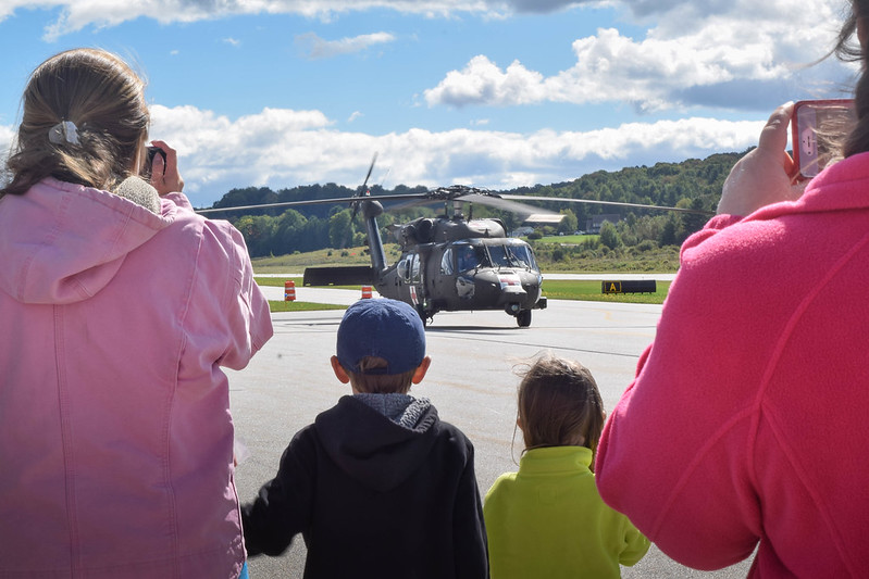 Two adults and two children watching a helicoptor