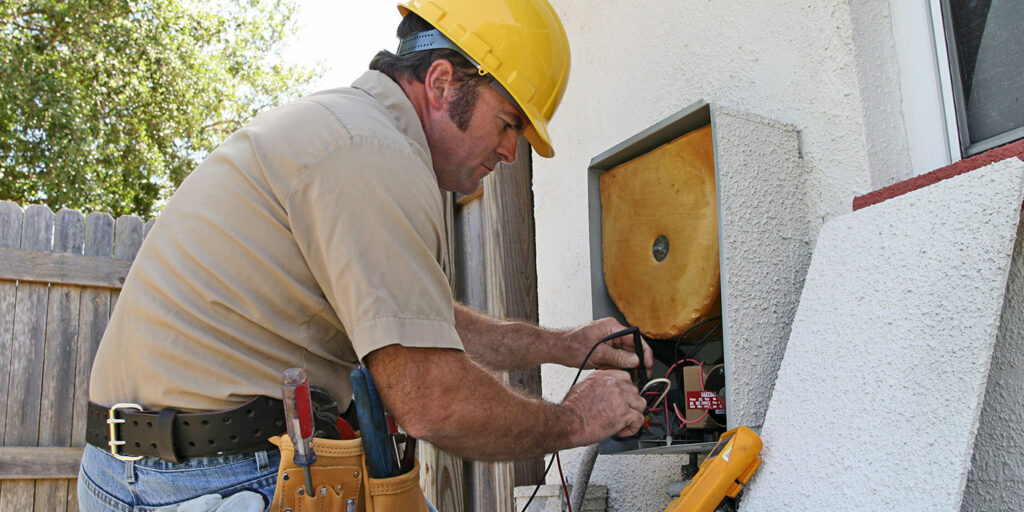 Man in safety hat repairing equipment